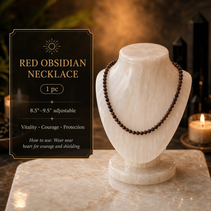 A red obsidian bead necklace displayed on a white bust