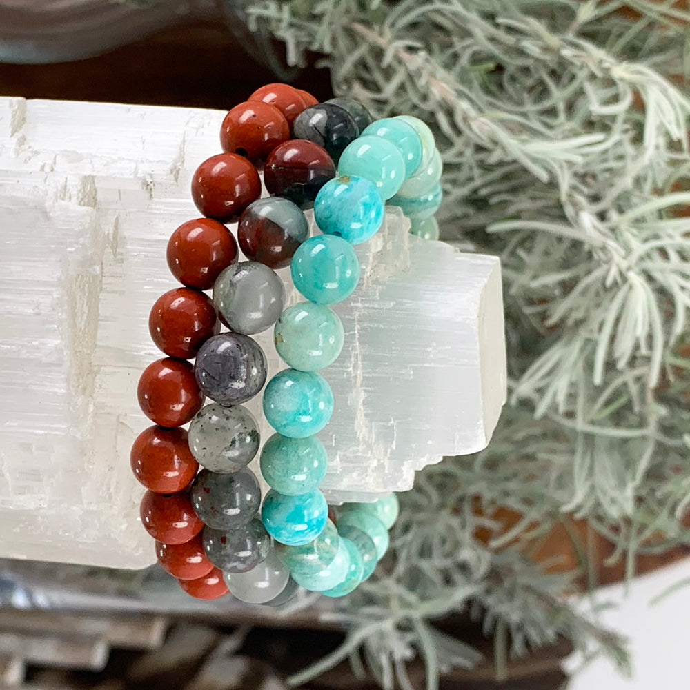 Red jasper, African blood and amazonite bead bracelets stacked on a selenite tower