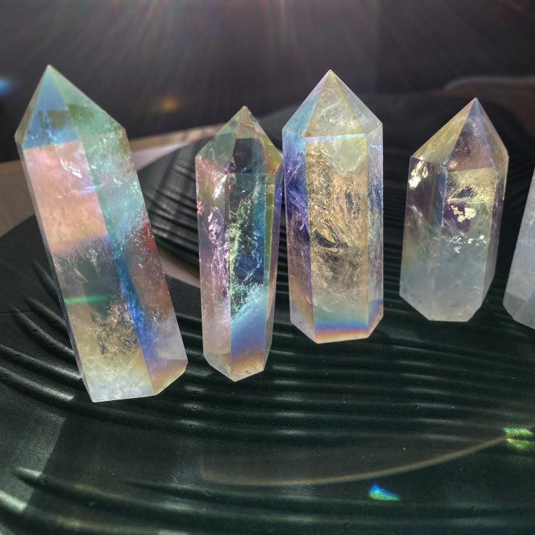 A row of Angel Aura quartz points of different heights in sunlight, each showing its own rainbow sheen and clear inner veils