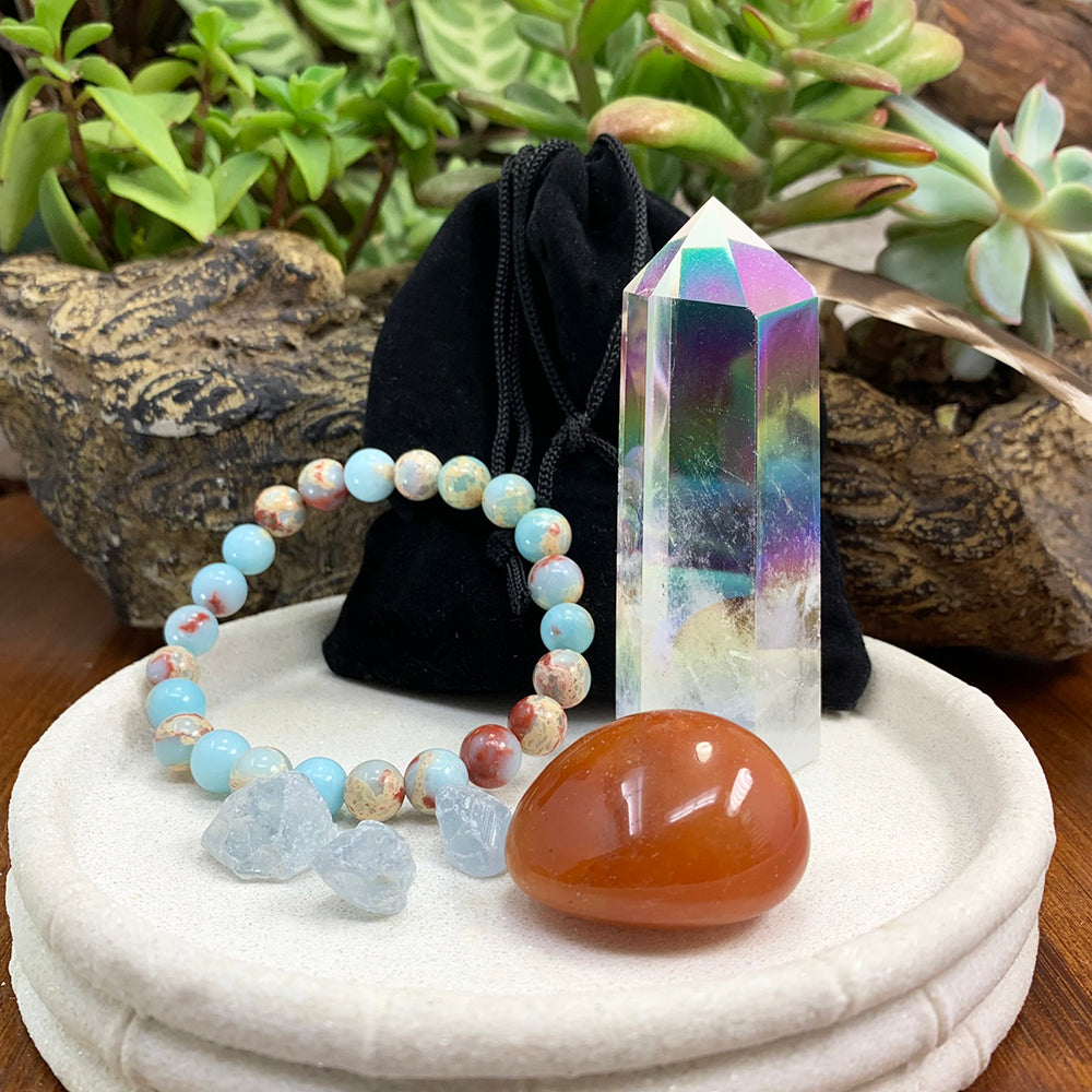 Angel aura point, azure variscite mala bracelet, red aventurine ellipse stone and three celestite minis together on a white dish