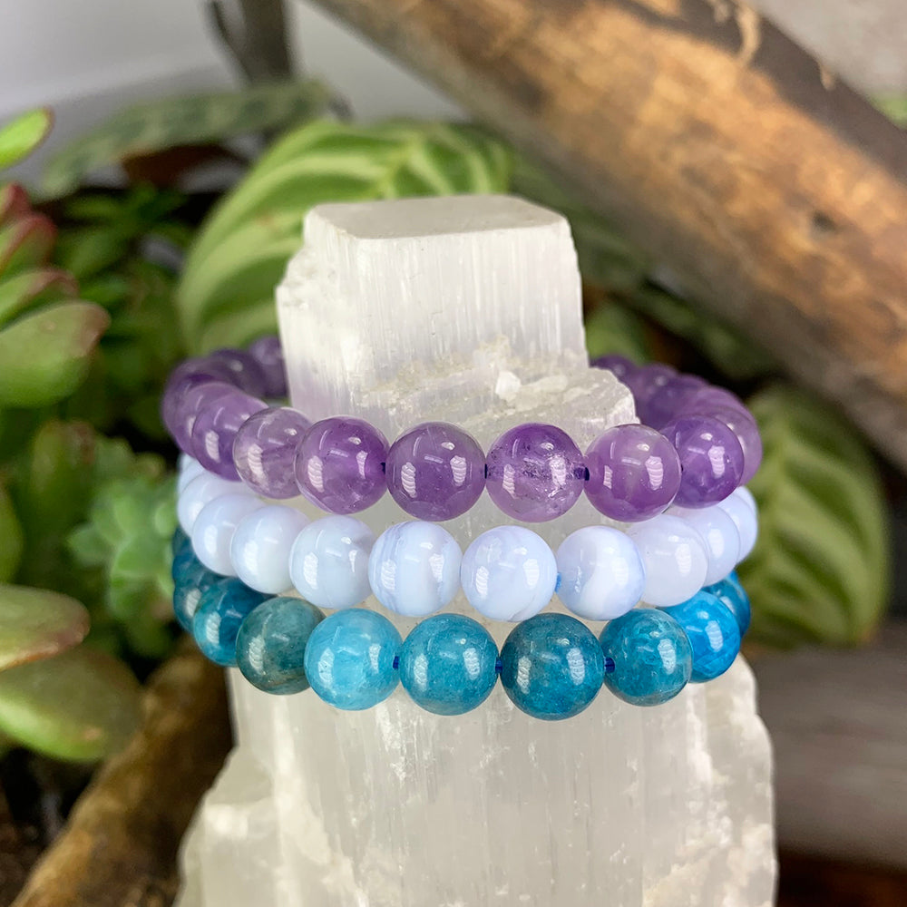 Amethyst, blue lace agate and apatite bead bracelets stacked on a selenite tower