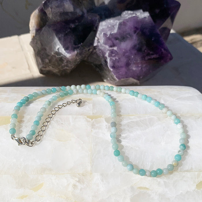 Caribbean jasper beaded necklace in soft aqua and white on a selenite slab