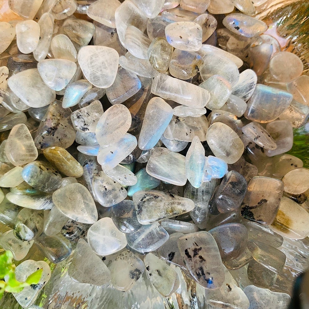 Close-up of tumbled flash labradorite minis showing blue sheen and dark inclusions