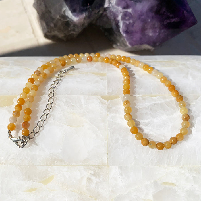 Yellow aventurine beaded necklace in honey-gold beads on a selenite slab